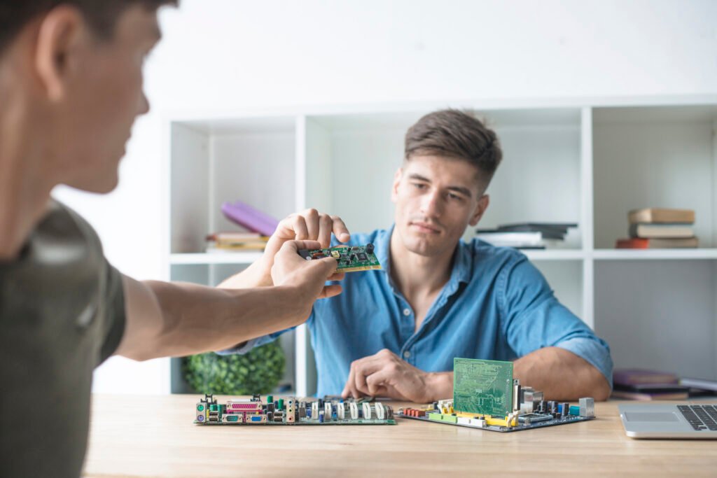 close-up-man-giving-circuit-board-his-friend-working-with-hardware-equipment